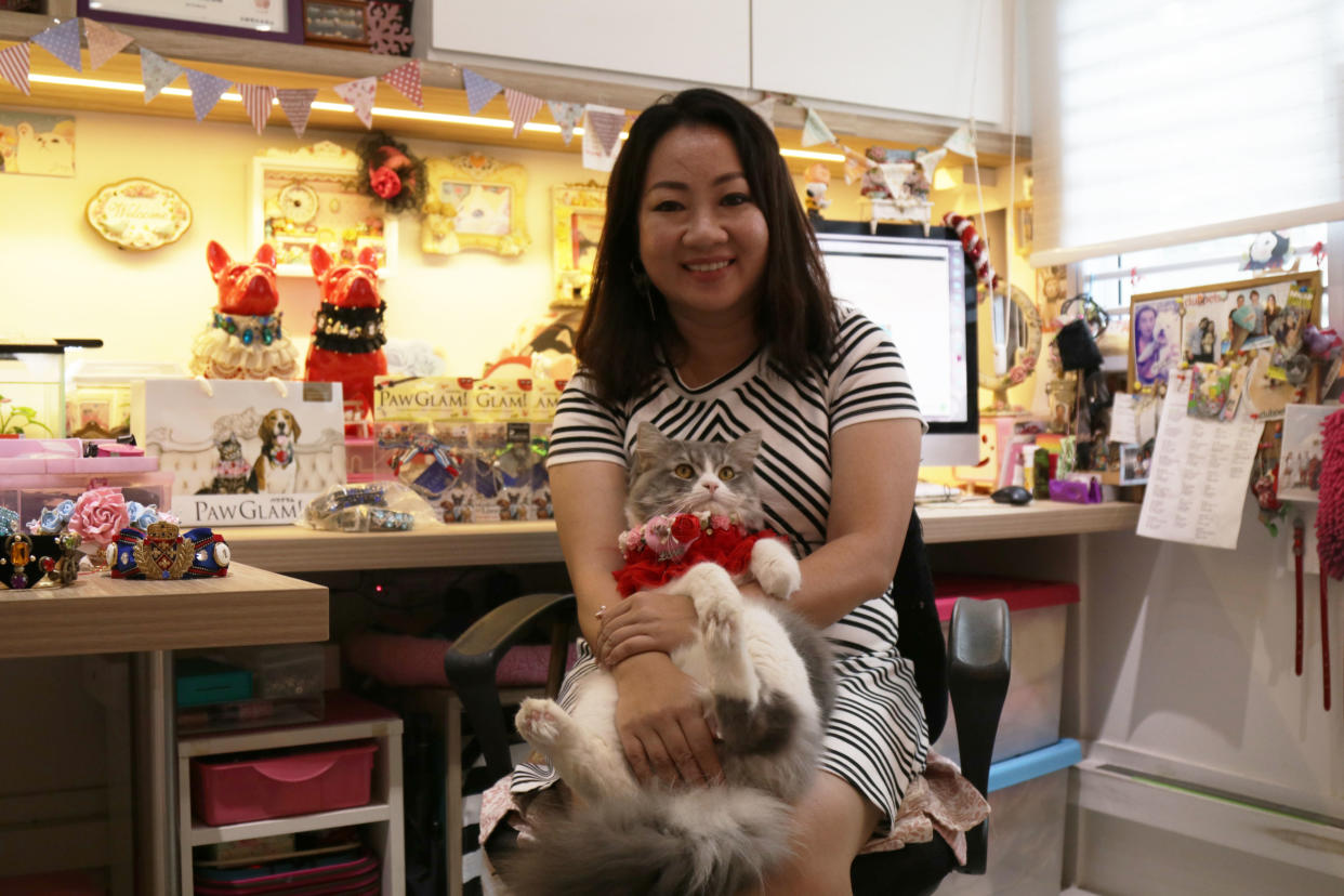 Pet fashion designer Sia Aiwei in her workshop at home with her cat Captain. (Photo: Abdul Rahman Azhari/Yahoo Lifestyle Singapore)