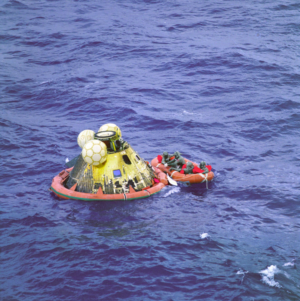 The Apollo 11 crew await pickup by a helicopter from the USS Hornet, prime recovery ship for the historic Apollo 11 lunar landing mission. The fourth man in the life raft is a United States Navy underwater demolition team swimmer. All four men are wearing Biological Isolation Garments (BIG). The Apollo 11 Command Module "Columbia," with astronauts Neil A. Armstrong, Michael Collins, and Edwin E. Aldrin Jr. splashed down at 11:49 a.m. (CDT), July 24, 1969, about 812 nautical miles southwest of Hawaii and only 12 nautical miles from the USS Hornet. (Photo: NASA)