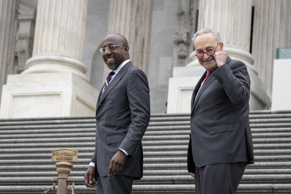 Senate Majority Leader Chuck Schumer and Sen. Raphael Warnock walk up the Senate steps as Warnock returns to Washington after winning the Georgia runoff election. 