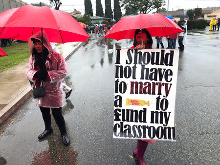 Los Angeles teachers carry signs as they picket in the rain in Los Angeles, California, U.S. January 16, 2018. REUTERS/Dan Whitcomb