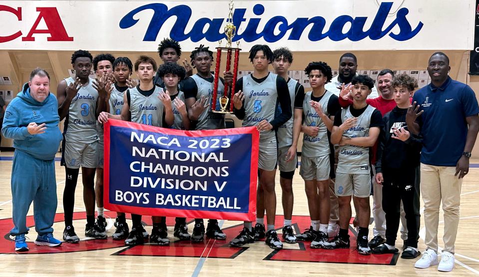 Jordan Christian Prep players and coaches pose with the championship trophy by his teammates as they celebration winning the NACA Division 5 national tournament.