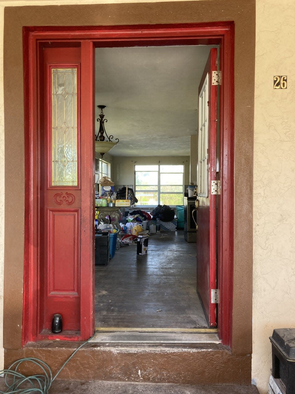 Through Warren Adkins' front door, you can see most of his belongings are gone, after Hurricane Ian's storm surge swept through his home. Cleaning supplies are stacked along the floor.