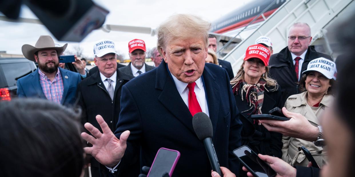 Former President Donald Trump speaks with reporters as he lands at Quad City International Airport en route to Iowa on Monday, March 13, 2023.