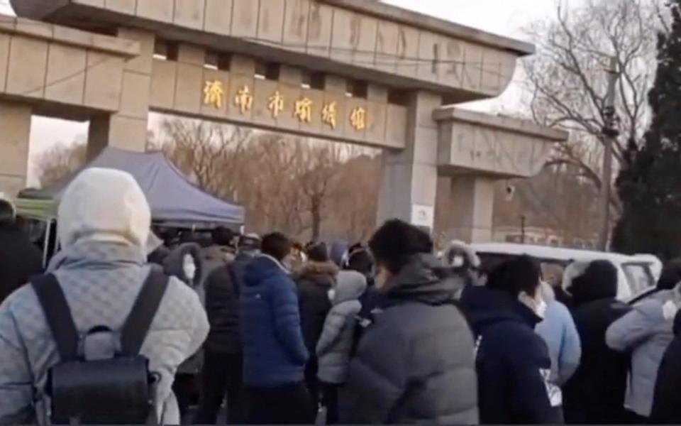 La gente espera fuera de una funeraria en Jinan, provincia de Shandong - Reuters