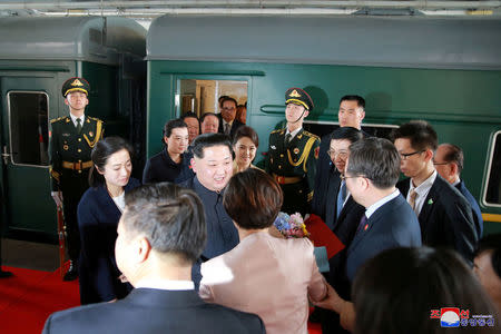 North Korean leader Kim Jong Un and his wife Ri Sol Ju are seen near a train as he paid an unofficial visit to Beijing, China, in this undated photo released by North Korea's Korean Central News Agency (KCNA) in Pyongyang March 28, 2018. KCNA/via Reuters