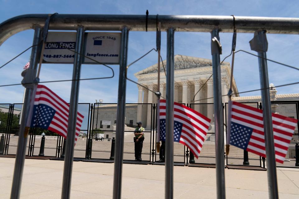 Abortion-rights activists leave hangers on the fence as they protest outside the Supreme Court in Washington on July 4.