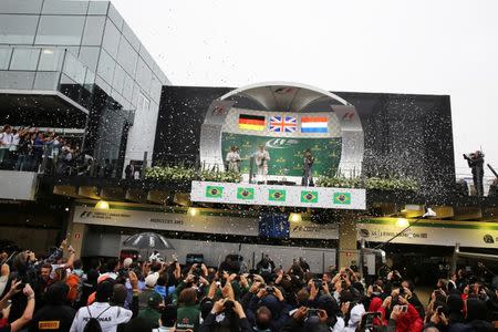 Formula One - F1 - Brazilian Grand Prix - Circuit of Interlagos, Sao Paulo, Brazil - 13/11/2016 - First placed Mercedes driver Lewis Hamilton of Britain, second placed and teammate Nico Rosberg of Germany and third placed Red Bull driver Max Verstappen of the Netherlands spray champagne during the victory ceremony. REUTERS/Nacho Doce