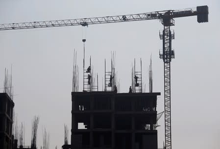 FILE PHOTO: Labourers work at the construction site of a residential building on the outskirts of Kolkata