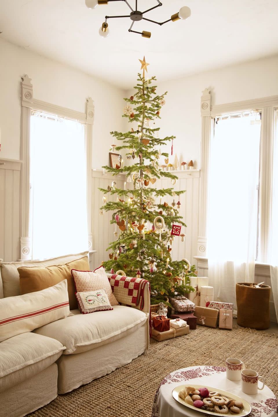 <p>Skinnier branches can be just as pretty as a full-blown fir, and don't feel overwhelming in cozy corners. Add woodland creature and felt mushroom ornaments to bring the outdoors in.</p>