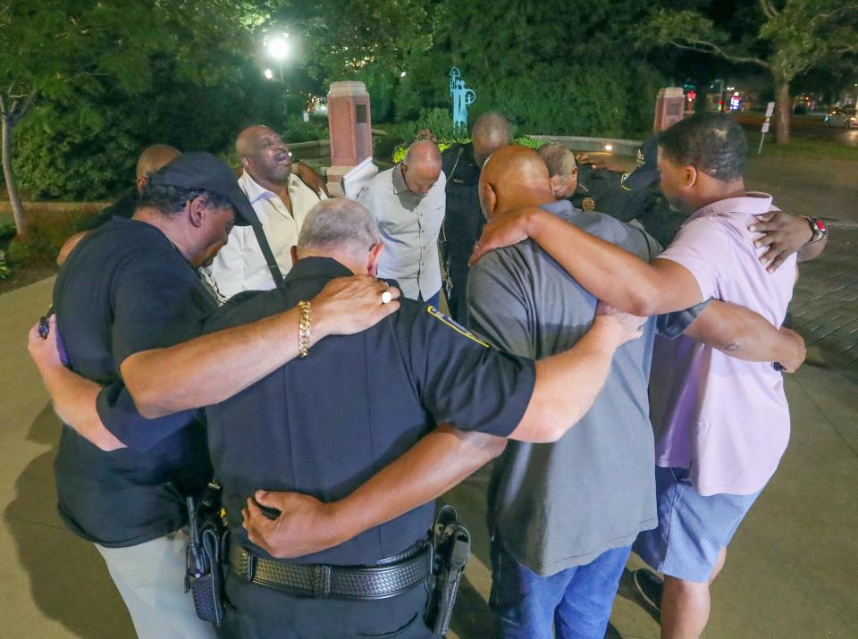 The Rev. Lorenzo Glenn of the Macedonia Baptist Church leads Akron Mayor Dan Horrigan, Police Chief Stephen Mylett and other city officials in prayer outside Akron Children's Hospital on July 8, 2022, before a press conference announcing the shooting death of a 4-yea- old girl.