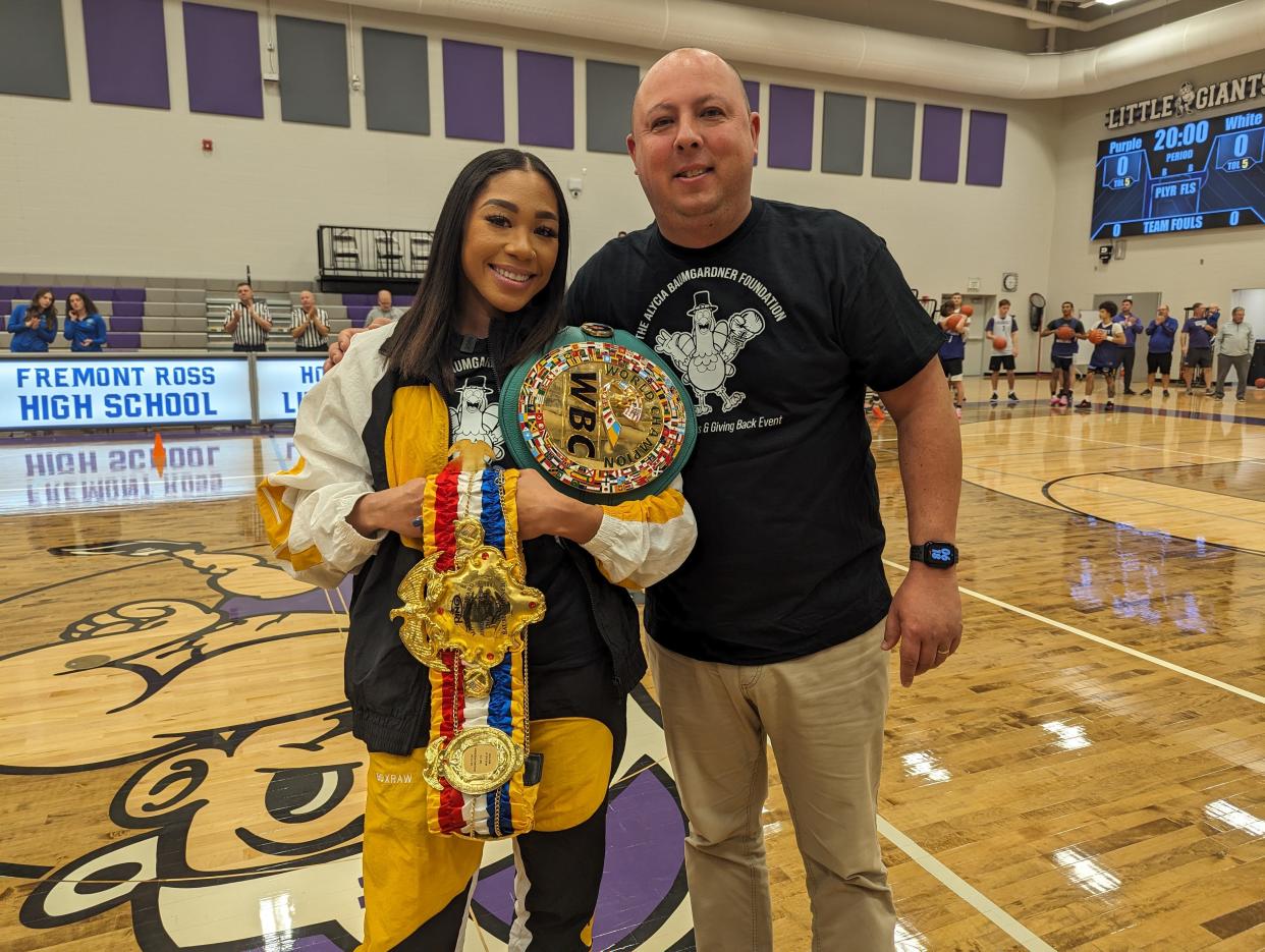 World champion boxer Alycia Baumgardner shows off her belts with Fremont Mayor Danny Sanchez during a basketball rally on Nov. 9, 2023, at Fremont Ross High School, which was also a Thanksgiving turkey give-away she sponsored.