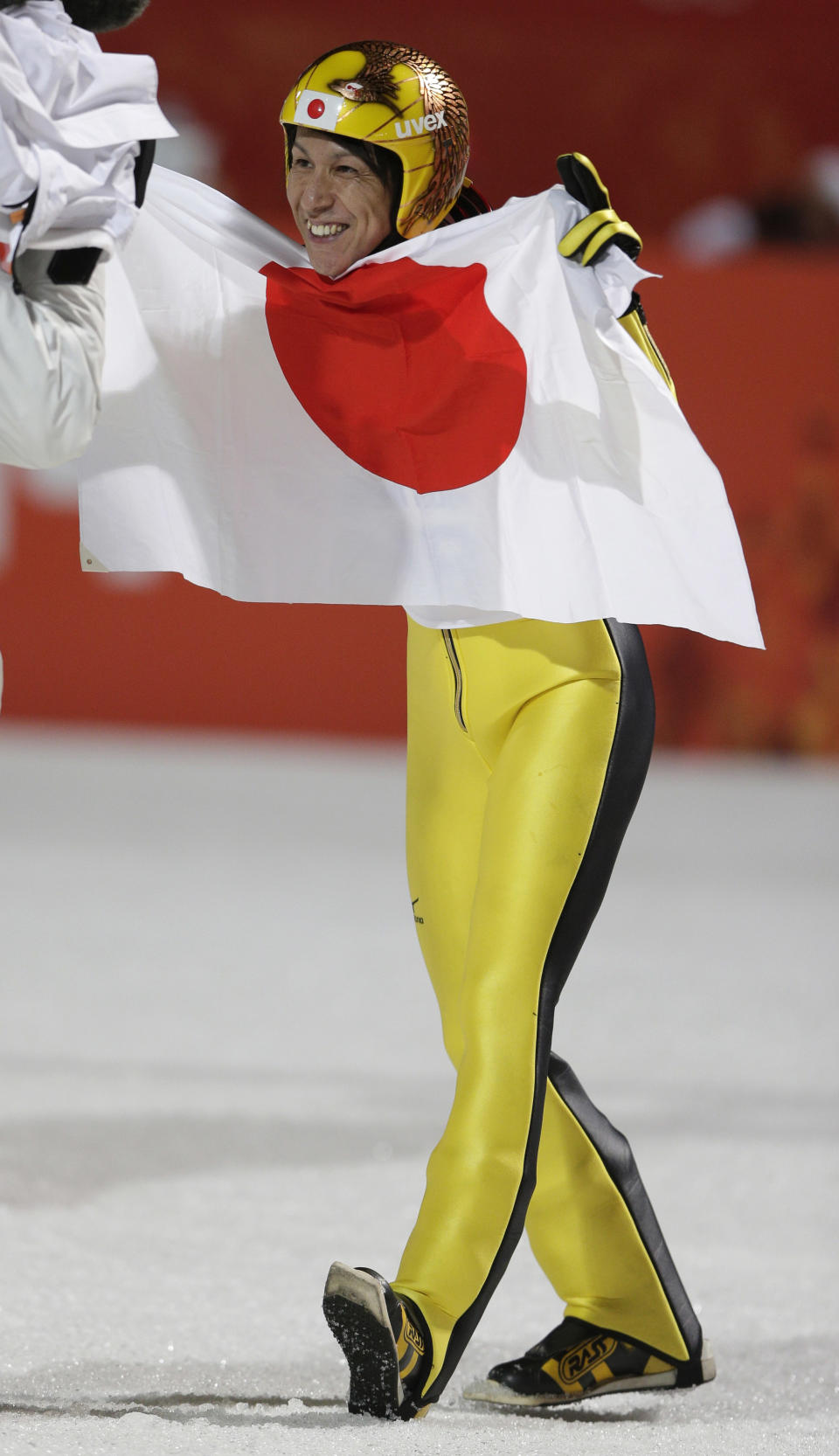 Japan's Noriaki Kasai celebrates with the Japanese flag after winning the silver during the ski jumping large hill final at the 2014 Winter Olympics, Saturday, Feb. 15, 2014, in Krasnaya Polyana, Russia. (AP Photo/Matthias Schrader)