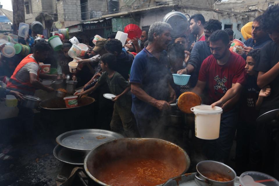 巴勒斯坦民眾13日在南部拉法領取食物。美聯社