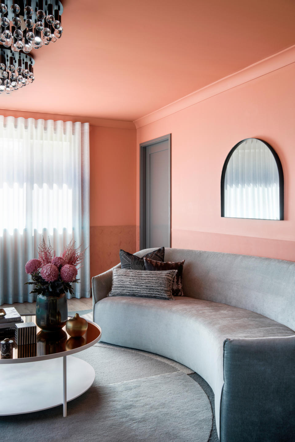 Living room with two-tone terracotta walls and ceiling and silver grey sofa and rug