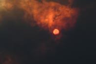 The sun is seen through heavy smoke as a bushfire burns in Woodford NSW
