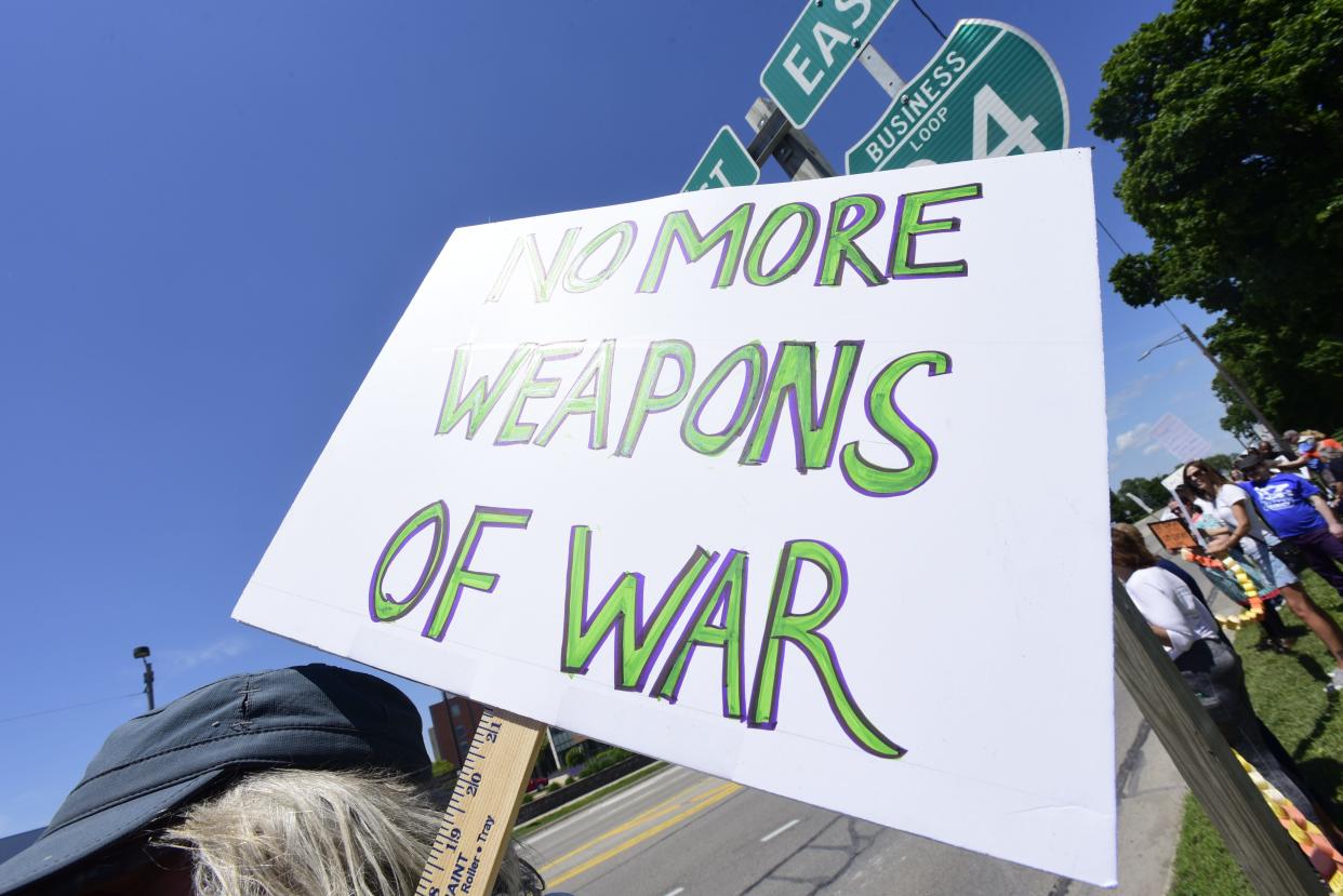 An activist holds a sign reading, "no more weapons of war" to protest gun violence during a rally put on by the St. Clair County Democrats at Pine Grove Park in downtown Port Huron on Saturday, June 11, 2022.