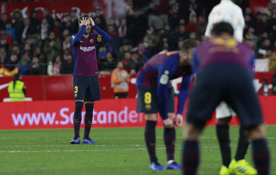 FC Barcelona's Gerard Pique, left, reacts after Sevilla's Pablo Sarabia scored during a Spanish Copa del Rey soccer match between Sevilla and FC Barcelona in Seville, Spain, Wednesday Jan. 23, 2019. Sevilla won 2-0. (AP Photo/Miguel Morenatti)