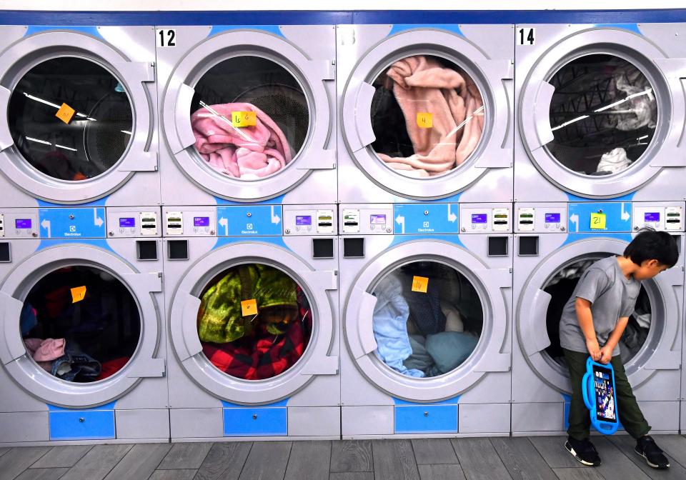 Sebastian Villeda, 7, keeps an eye on the dryers as he waits for his grandmother Angel Villeda's laundry to finish Dec. 7 at Laundry Luv. The laundromat was offering free washes and other giveaways for the day.