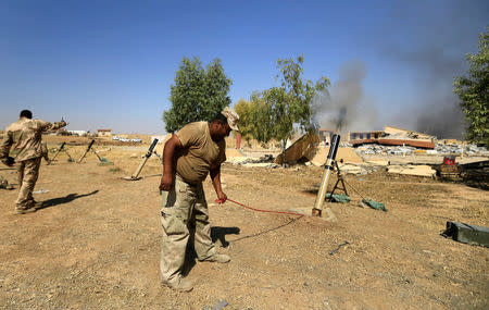 Members of Iraqi Army fire mortar shells during the war between Iraqi army and Shi'ite Popular Mobilization Forces (PMF) against the Islamic State militants in al-Ayadiya, northwest of Tal Afar, Iraq August 28, 2017. REUTERS/Thaier Al-Sudani