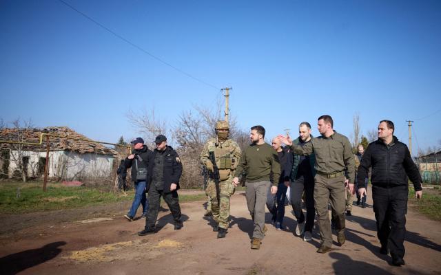 Zelensky walks along a street in a village - UKRAINIAN PRESIDENTIAL PRESS SERVICE/via REUTERS