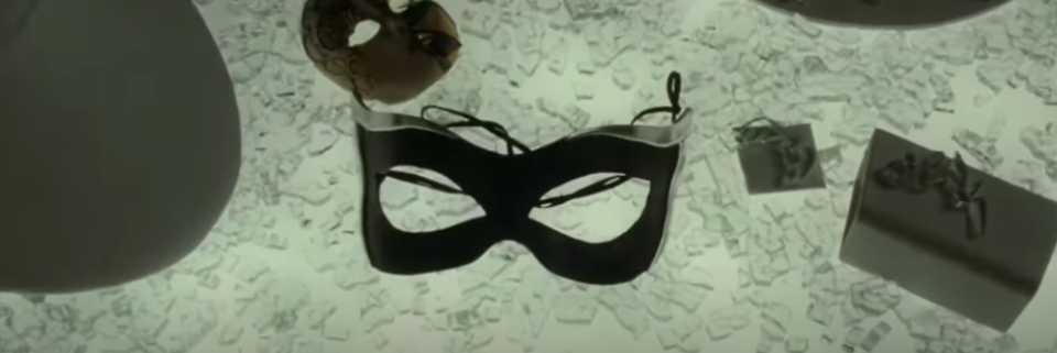 A Catwoman mask on top of broken glass
