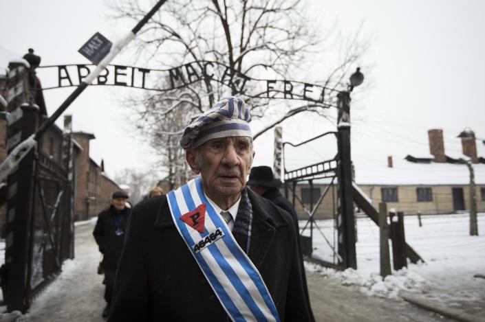Survivors walk under the sign saying "Work makes you free" after paying tribute to fallen comrades at the former Auschwitz concentration camp in Oswiecim, Poland, on January 27, 2015 (AFP Photo/Odd Andersen)