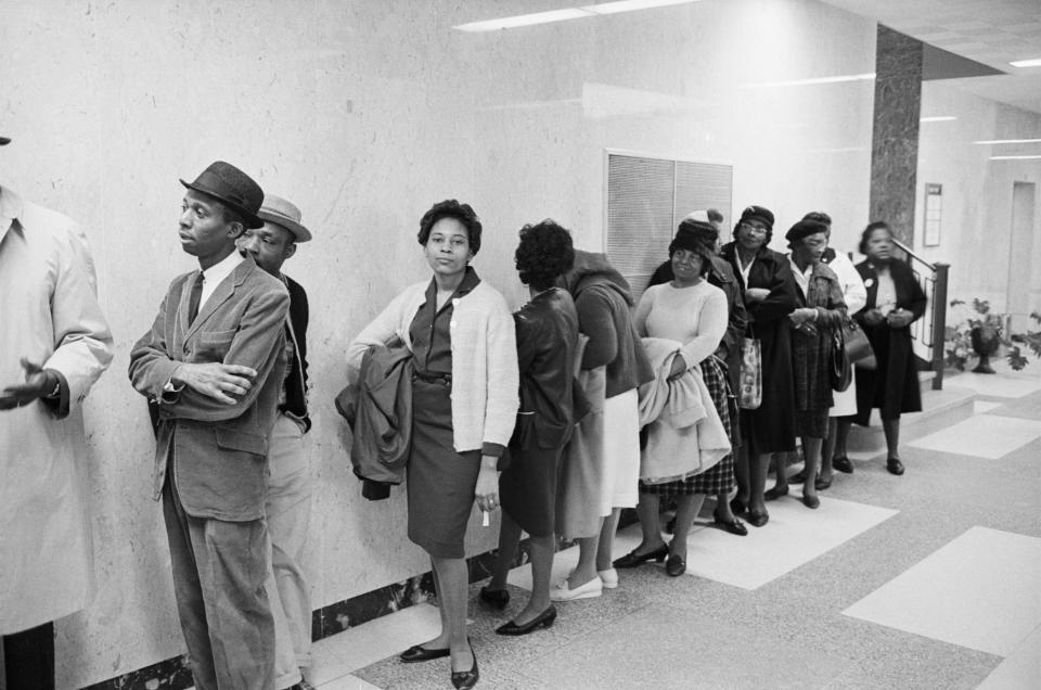 A black-and-white picture of Black people waiting in line.
