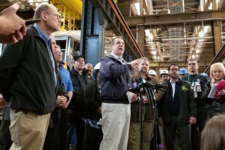 New York Governor Andrew Cuomo talks to reporters as Joseph Lhota (L), Chairman of the Metropolitan Transportation Authority, looks on, inside the 207th Street Overhaul Shop where subway cars are refurbished, in Manhattan, New York, U.S., April 6, 2018.     REUTERS/Hilary Russ