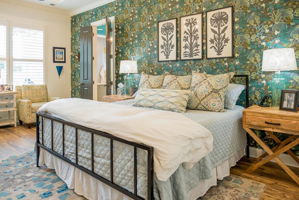 The primary bedroom features a wallpapered wall behind the headboard.