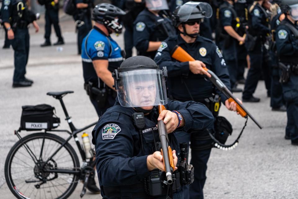 Austin Police officer Justin Berry points a shotgun with so-called less-lethal rounds at protesters gathered in front of Austin City Hall on May 31, 2020, to protest the death of George Floyd at the hands of Minneapolis police a few days earlier. Berry is one of 21 Austin police officers accused of using excessive force during the protests.