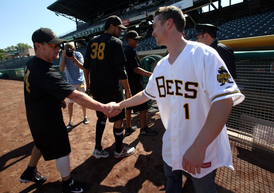 Victor DiMattia shakes hands with a Bees player. 