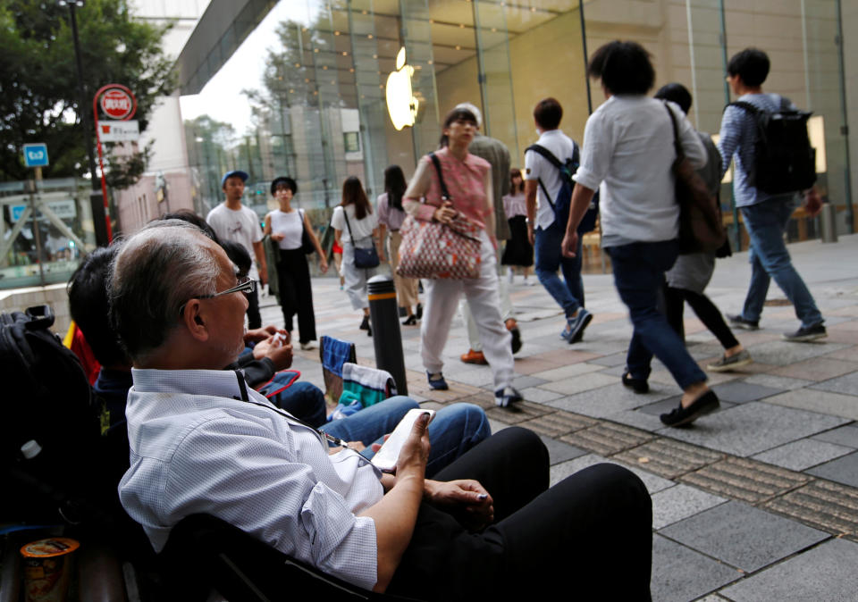 People sit in queue for the release of Apple's new iPhone 7 and 7 Plus in front of the Apple Store in Tokyo's Omotesando shopping district, Japan September 15, 2016. REUTERS/Toru Hanai