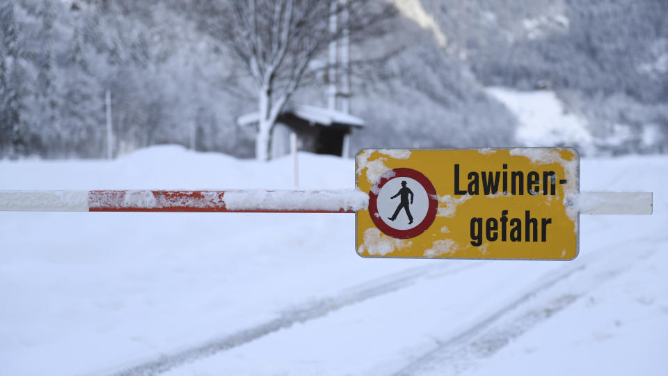A danger sign " danger of avalanches" displayed at a closed street in Weissbach near Lofer, Austrian province of Salzburg on Friday, Jan. 11, 2019.(AP Photo/Kerstin Joensson)