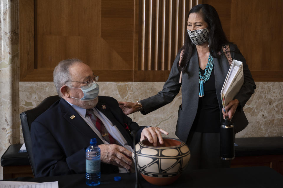 Rep. Deb Haaland, D-N.M., delivers a gift to Rep. Don Young, R-Alaska, before the start of the Senate Committee on Energy and Natural Resources hearing on her nomination to be Interior Secretary, Tuesday, Feb. 23, 2021 on Capitol Hill in Washington. (Jim Watson/Pool via AP