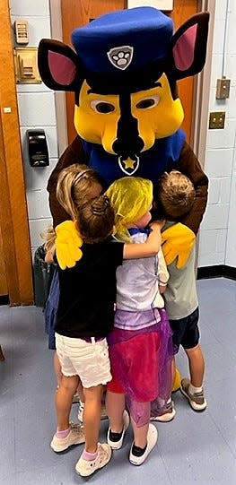 A member of the PAW Patrol receives hugs from students attending the Extended School Year (ESY) Program.