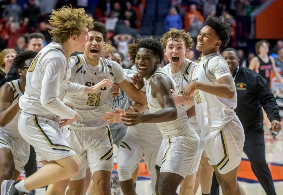 Springfield Sacred Heart-Griffin's KeShon Singleton, middle, and his teammates celebrate after Singleton's last-second three-pointer in double overtime gave the Cyclones a 53-50 win over the Metamora Redbirds for the Class 3A state basketball title Saturday, March 12, 2022 at the State Farm Center in Champaign.