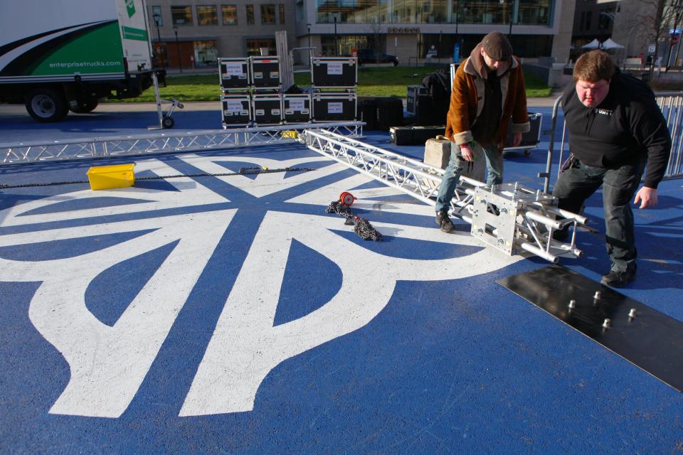 Creighton Lowe and Zach Werner, of Hamilton AV, work to install a video screen on Parcel 5 Monday morning. The 16X9 foot screen will be used to stream the solar eclipse later in the day.