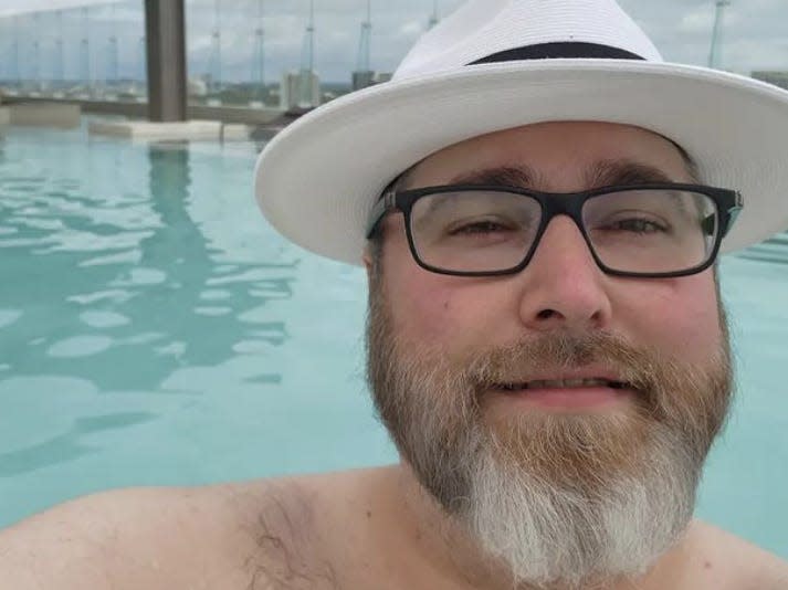 Selfie of Brian Levinson wearing a fedora in a swimming pool