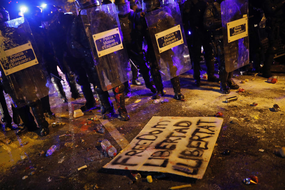 A poster lies on the ground during clashes between protestors and riot police outside the Spanish Government Office in Barcelona, Spain, Tuesday, Oct. 15, 2019. Spain's Supreme Court on Monday convicted 12 former Catalan politicians and activists for their roles in a secession bid in 2017, a ruling that immediately inflamed independence supporters in the wealthy northeastern region. (AP Photo/Bernat Armangue)