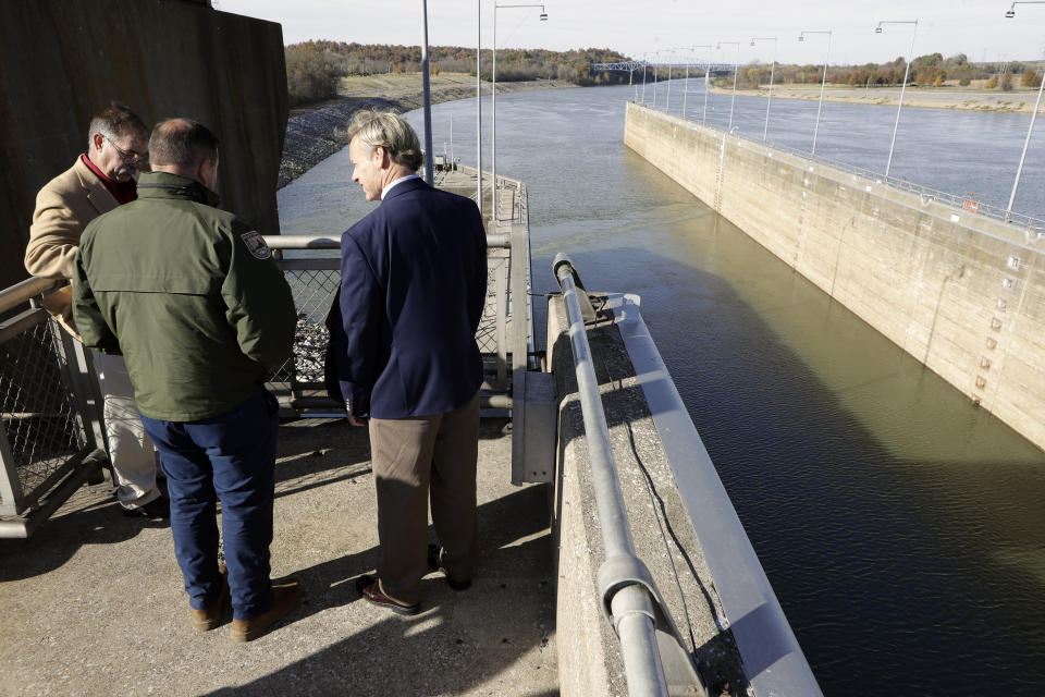 People look over the Barkley Lock and Dam where the Cumberland River meets Lake Barkley, Friday, Nov. 8, 2019, in Grand Rivers, Ky. A noise-making, bubbling, bio-acoustic fish fence has been installed in the lock to deter the spread of destructive Asian carp . (AP Photo/Mark Humphrey)