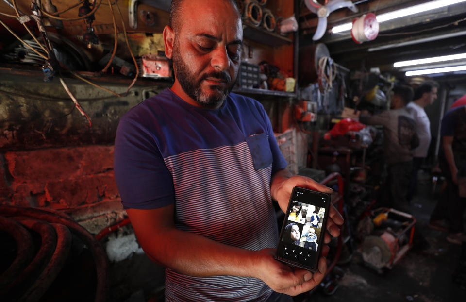 Mohammed Khier Qalaji, the brother of Firas Qalaji a Syrian man who died during the floods in the Libyan city of Derna, shows through his mobile phone the children of his brother who were also killed with their father, in Damascus, Syria, Saturday, Sept. 16, 2023. Firas Qalaji, 45, a car mechanic, had been living in Libya since 2000 and his wife Rana Khateeb and their six children were to be buried in Libya, the family said in a statement. (AP Photo/Omar Sanadiki)