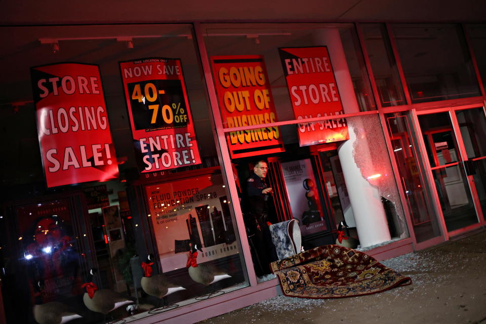 Police officer investigates on October 28, 2020 in a store that was looted in unrest following the death of Walter Wallace Jr., a Black man who was shot by police, in Philadelphia / Credit: HANNAH MCKAY / REUTERS