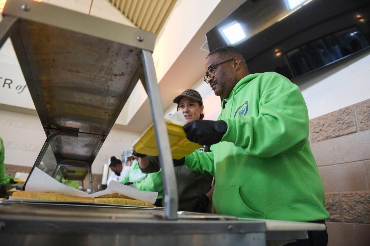 President and CEO of Golden Harvest Food Bank Amy Breitmann (left) and Mayor Garnett Johnson (right) load trays with food during the second annual MLK Day of Service at The Master's Table on Monday, Jan. 15, 2024. Golden Harvest Food Bank prepared to serve about 300 lunches, in addition to medical screenings by Augusta University students, and showers through Project Refresh.