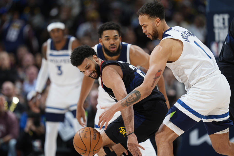 Denver Nuggets guard Jamal Murray, front left, loses control of the ball as Minnesota Timberwolves forward Kyle Anderson, front right, and center Karl-Anthony Towns defend in the second half of Game 2 of an NBA basketball second-round playoff series, Monday, May 6, 2024, in Denver. (AP Photo/David Zalubowski)