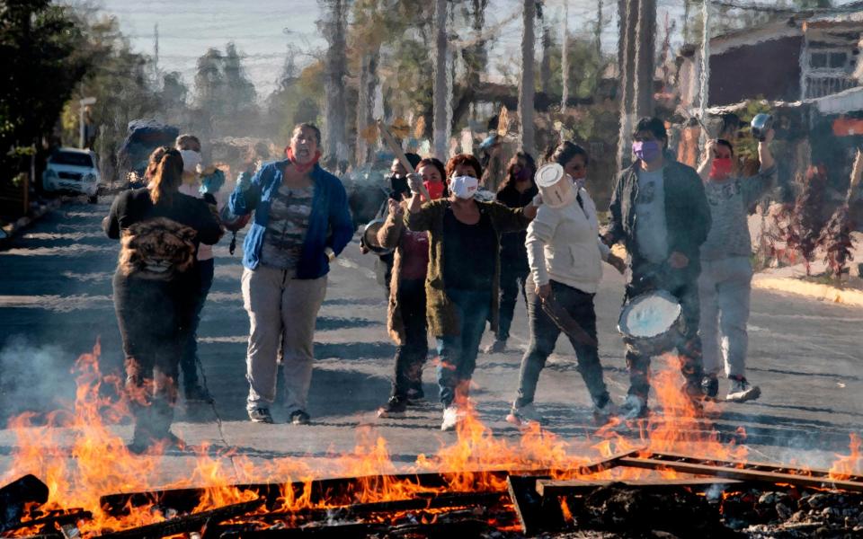 Demonstrators set up a fire barricade  -  MARTIN BERNETTI/AFP 