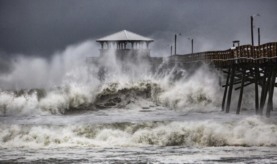 Waves slam the Oceana Pier and Pier House Restaurant in Atlantic Beach, North Carolina, on Thursday.