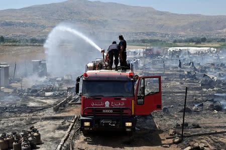 Civil defence members put out fire at a camp for Syrian refugees near the town of Qab Elias, in Lebanon's Bekaa Valley, July 2, 2017. REUTERS/Hassan Abdallah