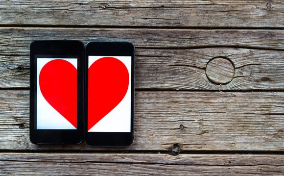 Two mobile phones with a heart displayed across both of them