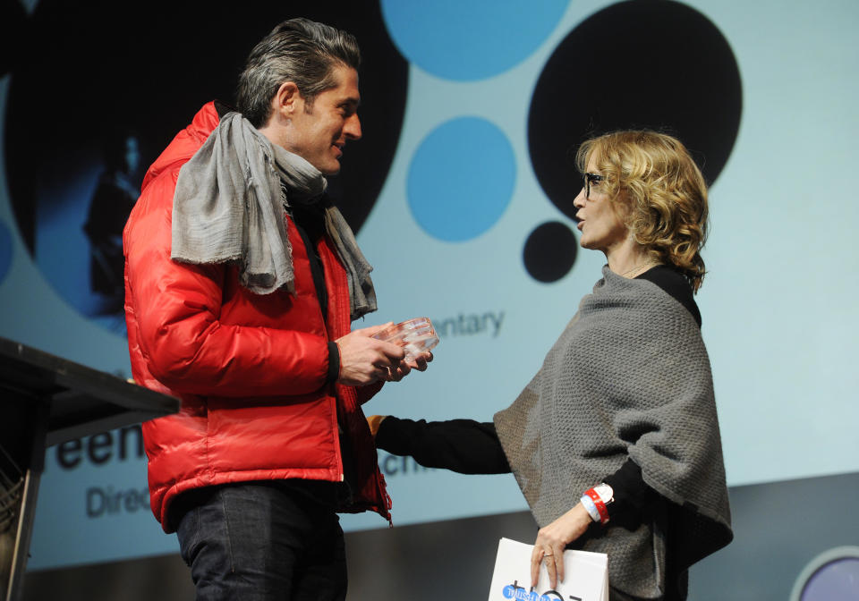 Nadav Schirman, left, director of "The Green Prince," accepts the Audience Award: World Cinema Documentary from actress Felicity Huffman during the 2014 Sundance Film Festival Awards Ceremony on Saturday, Jan. 25, 2014, in Park City, Utah. (Photo by Chris Pizzello/Invision/AP)