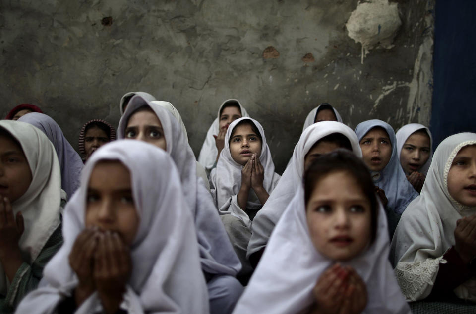 <p>Pakistani schoolgirls, who were displaced with their families from Pakistan’s tribal areas due to fighting between militants and the army, chant prayers during a class to pay tribute for five female teachers and two aid workers who were killed by gunmen at a school in a slum on the outskirts of Islamabad, Pakistan, Jan. 3, 2013. Gunmen in northwest Pakistan killed five female teachers and two aid workers on Tuesday in an ambush on a van carrying workers home from their jobs at a community center, officials said. (Photo: Muhammed Muheisen/AP) </p>